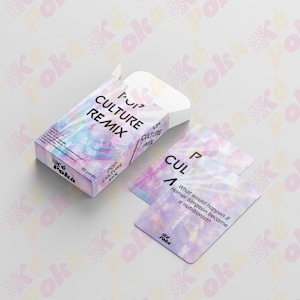 Puede incluir: Una caja de juego de cartas y cartas con un diseño holográfico. La caja dice "POP CULTURE REMIX" y "50 cartas". Una carta pregunta: "¿Qué pasaría si Homer Simpson se convirtiera en nutricionista?" en una fuente lúdica.