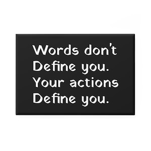 Puede incluir: Un imán rectangular negro con texto blanco que dice "Words don't Define you. Your actions Define you."