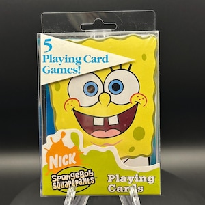 May include: A pack of SpongeBob SquarePants playing cards. The packaging features a smiling SpongeBob character with blue eyes and a yellow body. The text "5 Playing Card Games!" is visible.