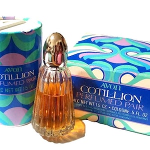 Op de afbeelding: Een Avon Cotillion Perfumed Pair set, inclusief een flesje eau de cologne, talkpoeder en een bijpassende doos. De verpakking heeft een blauw, turquoise en roze golfpatroon. Het eau de cologne flesje is helder met een gouden dop.