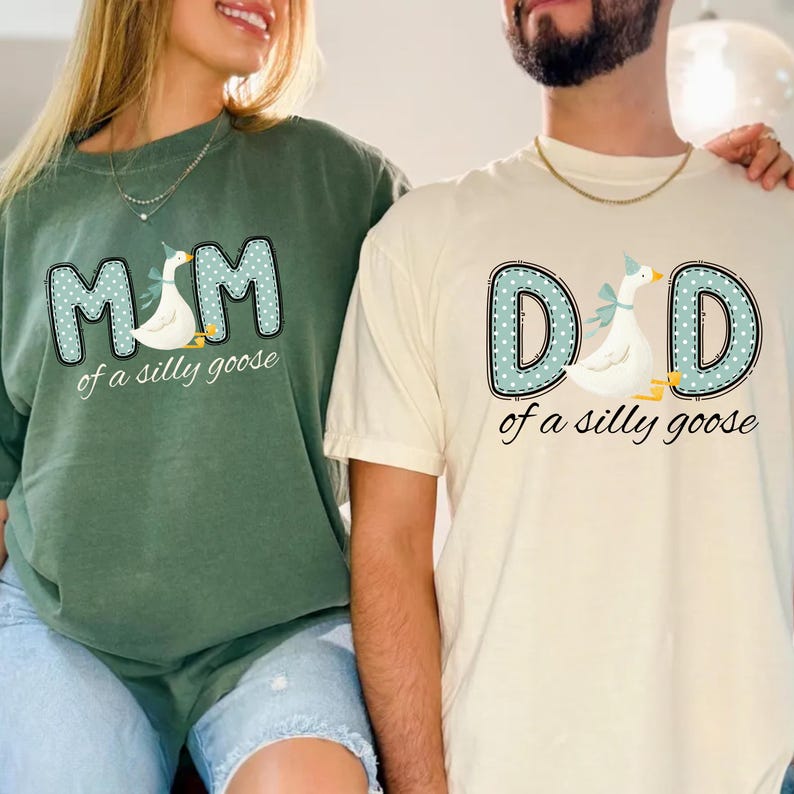 May include: Two t-shirts, one green and one cream-colored, feature the text "MOM" and "DAD" in a dotted blue font, each with a goose illustration wearing a party hat. The phrase "of a silly goose" is below the text.