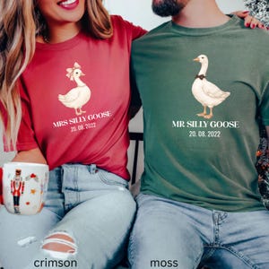Peut inclure: T-shirts rouge cramoisi et vert mousse avec des illustrations d'oies et du texte. Le t-shirt rouge dit "MRS SILLY GOOSE 20.08.2022" et le t-shirt vert mousse dit "MR SILLY GOOSE 20.08.2022".