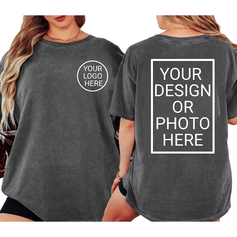 Puede incluir: Dos camisetas gris carb&oacute;n. Una muestra un c&iacute;rculo blanco con el texto "YOUR LOGO HERE". La otra muestra un rect&aacute;ngulo blanco con el texto "YOUR DESIGN OR PHOTO HERE".