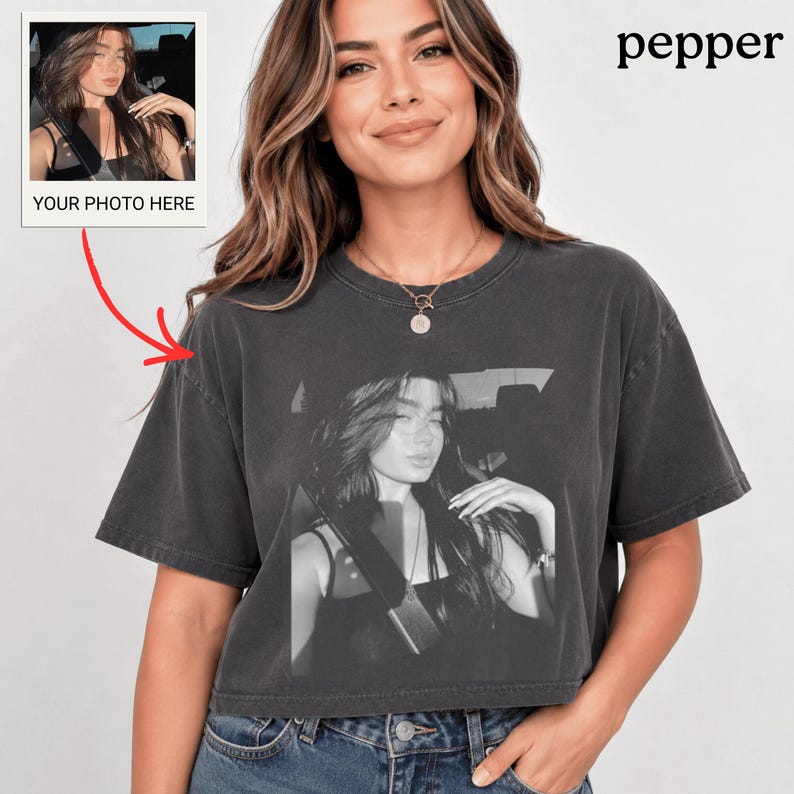 Puede incluir: Camiseta corta gris oscuro con una impresi&oacute;n fotogr&aacute;fica en blanco y negro de una persona. Una peque&ntilde;a foto con el texto "YOUR PHOTO HERE" est&aacute; en la esquina superior izquierda. La palabra "pepper" est&aacute; impresa en negro en la esquina superior derecha.