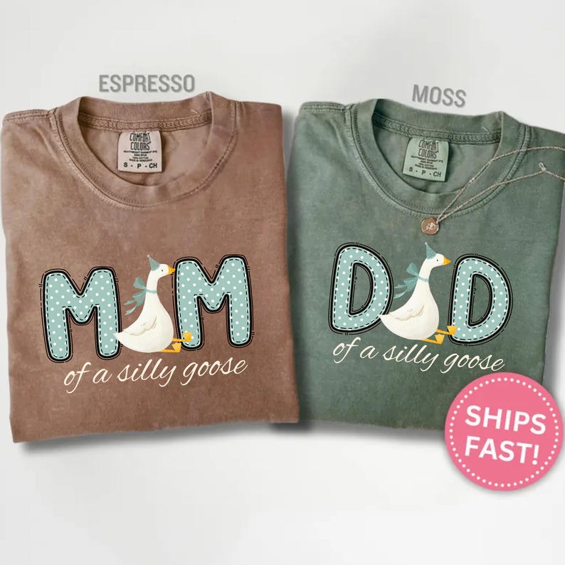 May include: Two t-shirts, one espresso brown and one moss green, feature the text "MOM" and "DAD" with a goose graphic. The shirts are made of a soft material and are perfect for parents.