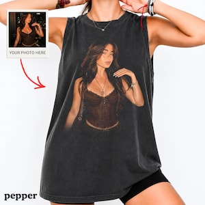 May include: A charcoal grey sleeveless tank top featuring a large, centered graphic print of a person with long brown hair wearing a dark brown corset top and a necklace. The graphic includes a small inset box labeled YOUR PHOTO HERE.