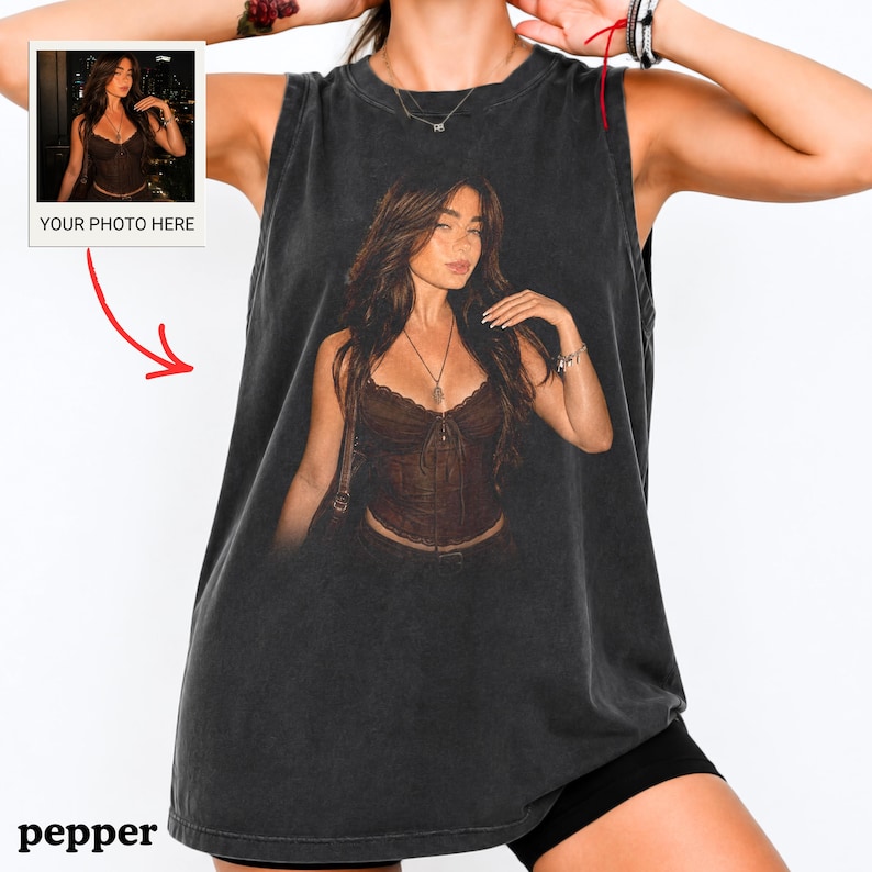 May include: A charcoal grey sleeveless tank top featuring a large, centered graphic print of a person with long brown hair wearing a dark brown corset top and a necklace. The graphic includes a small inset box labeled YOUR PHOTO HERE.