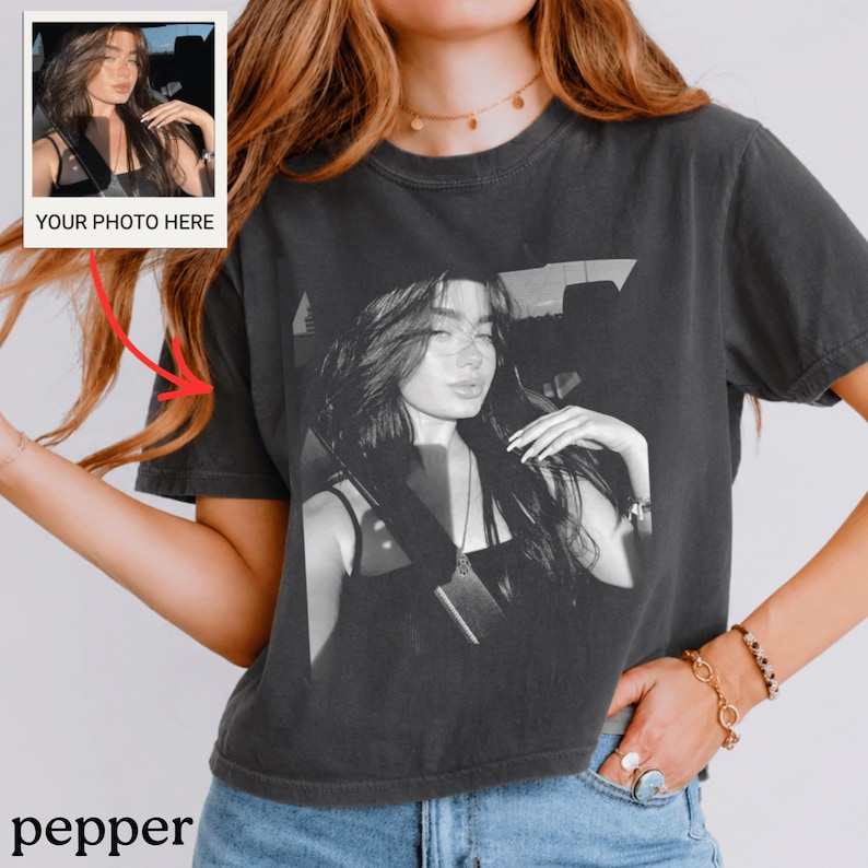 Puede incluir: Camiseta gris oscuro con una impresi&oacute;n fotogr&aacute;fica en blanco y negro de una persona. Una peque&ntilde;a foto con el texto "YOUR PHOTO HERE" est&aacute; en la esquina superior izquierda. La palabra "pepper" est&aacute; en la parte inferior de la camiseta.