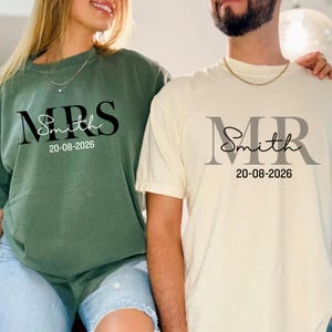May include: Two matching shirts, one green and one cream, with the text "MRS Smith 20-08-2026" and "MR Smith 20-08-2026" printed on the front. The green shirt is long-sleeved, and the cream shirt is short-sleeved. Both shirts are casual and suitable for a couple.