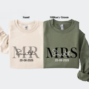 May include: Two crewneck sweatshirts, one sand-colored and one military green. The sand sweatshirt has "MR Smith" and the date "20-08-2026" printed on it. The green sweatshirt has "MRS Smith" and the same date.