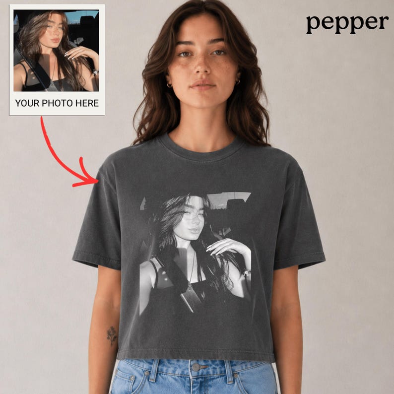 Puede incluir: Una camiseta corta gris carb&oacute;n con una imagen en blanco y negro de una mujer. La camiseta tiene un aspecto vintage y descolorido. Una peque&ntilde;a foto estilo polaroid con el texto "YOUR PHOTO HERE" est&aacute; en la esquina superior izquierda. La palabra "pepper" est&aacute; en la esquina superior derecha.