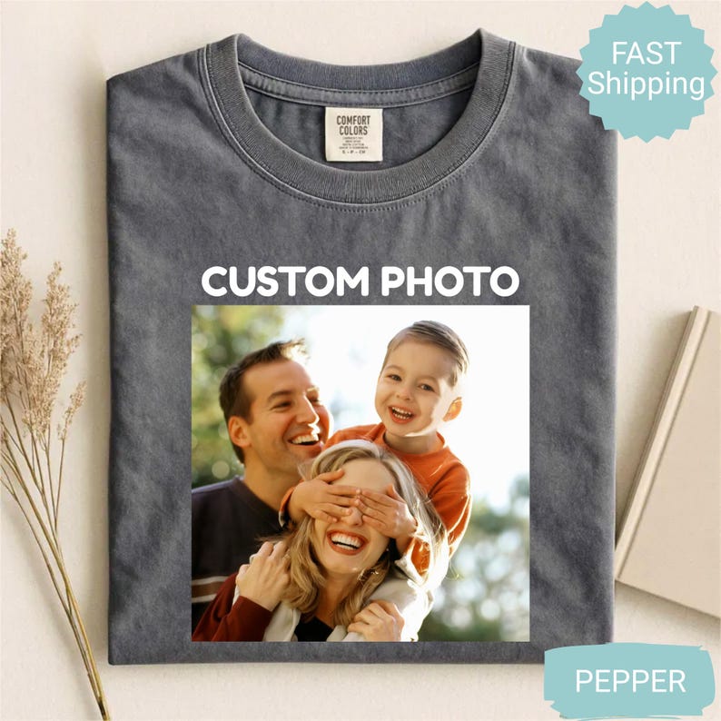 May include: A gray Comfort Colors t-shirt with a family photo and the text "CUSTOM PHOTO" printed on the front. The photo shows a smiling family. The shirt is a Pepper color.