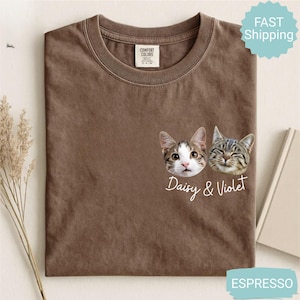 May include: Espresso-colored t-shirt featuring two cat faces with the names "Daisy & Violet" in a script font. The shirt is a Comfort Colors brand. The image also includes a "Fast Shipping" badge.