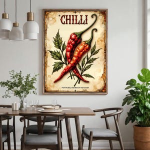 K&ouml;nnte beinhalten: Ein gerahmter Print im Vintage-Stil mit zwei roten Chilischoten mit gr&uuml;nen Stielen und Bl&auml;ttern. Das Wort "CHILLI" steht oben, und der Satz "FOR THE BOLD AND BRAVE IN THE KITCHEN" steht unten.