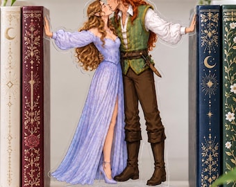 May include: A clear acrylic standee featuring an illustration of two figures kissing. One figure wears a long, light purple dress with long sleeves, and the other wears a green vest, white shirt, and brown trousers. They stand on a clear base.