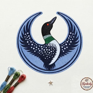 May include: Embroidered patch featuring a stylized loon bird with outstretched wings, set against a light blue crescent shape. The bird has a black head, red eye, and white and black body. The patch includes the text "Kimberly Embroidered Patches".