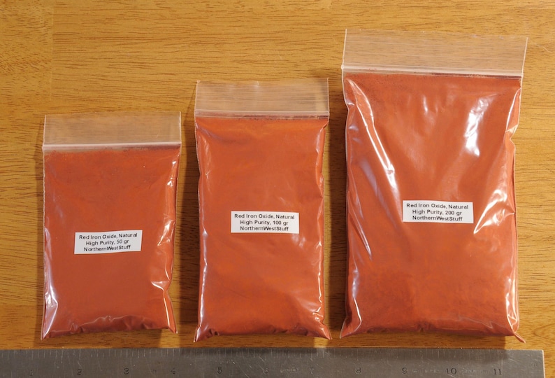 May include: Three clear plastic bags filled with red powder, labeled with white stickers. The bags contain 30g, 100g, and 200g of Red Iron Oxide, Natural, High Purity powder from NorthernWestStuff.