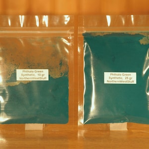 May include: Two clear plastic bags containing Phthalo Green synthetic pigment. One bag contains 10 grams, the other 25 grams. Each bag has a white label with the product name and the seller's name, NorthernWestStuff.