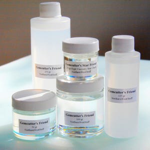 May include: A collection of clear bottles and jars with white lids, labeled "Gemcutter's Friend" and "Gemcutter's Star Friend." The labels indicate various weights: 50 gr, 100 gr, 125 gr, and 250 gr. The text "Northern WestStuff" is also visible.