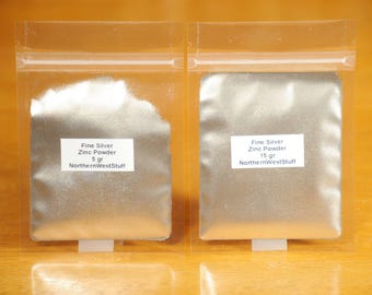 May include: Two clear plastic bags containing fine silver zinc powder. The bag on the left has a label that reads "Fine Silver Zinc Powder 5 gr NorthernWestStuff". The bag on the right has a label that reads "Fine Silver Zinc Powder 15 gr NorthernWestStuff".