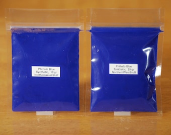 Puede incluir: Dos bolsas de plástico transparente llenas de polvo de pigmento azul vibrante. Las bolsas tienen etiquetas blancas con el texto "Phthalo Blue Synthetic" y el peso, 10 g y 25 g. El producto es de NorthernWestStuff.