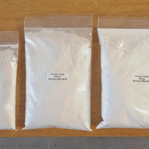 May include: Three clear plastic bags filled with white powder, labeled "French Chalk" and "Northern West Buff". The bags contain 100g, 250g, and 500g of chalk. A metal ruler is at the bottom.