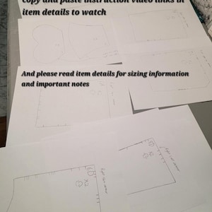 Pu&ograve; includere: Una collezione di modelli di carta bianca con note e diagrammi scritti a mano. Il testo sulla carta include istruzioni per copiare e incollare i collegamenti video e leggere i dettagli dell'articolo per le informazioni sulle dimensioni. I modelli sono per progetti di cucito.