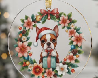 Könnte beinhalten: Ein klarer, runder Weihnachtsschmuck mit einem Boston Terrier, der einen Weihnachtsmannhut trägt und ein Geschenk hält. Der Hund ist von einem floralen Kranz mit roten und weißen Blumen, Tannenzapfen und Beeren umgeben. Oben hängt ein goldenes Band.