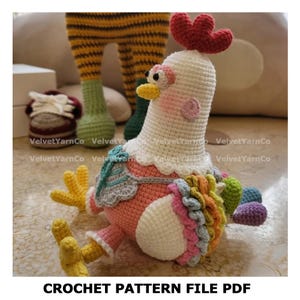 May include: A handmade crochet chicken with a red comb, yellow beak, and pink cheeks. The chicken is white, pink, and has colourful accents. The text "CROCHET PATTERN FILE PDF" is at the bottom. Other crochet items are in the background.