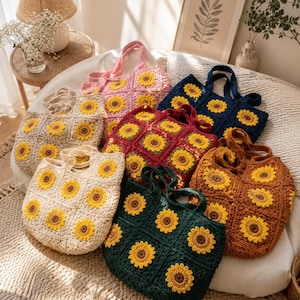 Puede incluir: Una colecci&oacute;n de seis bolsos tote de ganchillo hechos a mano, cada uno con un patr&oacute;n de girasol cuadrado. Los bolsos est&aacute;n disponibles en varios colores, incluyendo crema, rosa, azul oscuro, rojo intenso, verde oscuro y marr&oacute;n con p&eacute;talos amarillos.