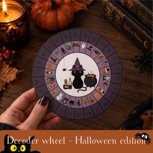 May include: A circular Halloween-themed decoder wheel featuring a black cat wearing a purple witch hat in the center, surrounded by a ring of alphabet letters from A to Z, each paired with small, colorful illustrations of spooky icons like ghosts.