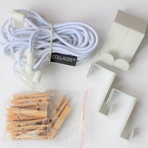 May include: A set of white plastic hooks, a white elastic cord, and a bag of wooden clothespins. The hooks have a label that says "COLLAGEE&reg;".