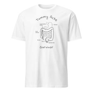 May include: White t-shirt with a black line drawing of the human digestive system. The words "Tummy Ache Survivor" are written above and below the illustration. The shirt is made of a soft, comfortable material.