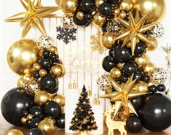 May include: A festive party decoration arrangement featuring gold and black balloons, star-shaped ornaments, and a small Christmas tree. The backdrop includes the text "Let's Party" and decorative snowflakes. A light-up reindeer adds to the celebratory theme.