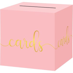 May include: A light pink card box with a slot on top. The word "cards" is written in gold script on the front and side of the box. This box is ideal for weddings, parties, or other events.
