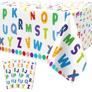 May include: A white rectangular tablecloth featuring a colorful alphabet pattern with letters in various fonts, patterns, and bright colors. A row of solid colored circles lines the bottom edge. Three matching napkins are displayed in the foreground.