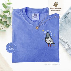 Maglietta con piccione spaziale, maglietta con piccione divertente ricamato, maglietta con simpatico animale cosmico, maglietta Comfort Colors, regalo per amanti dei piccioni, maglietta con animale carino Flo Blue