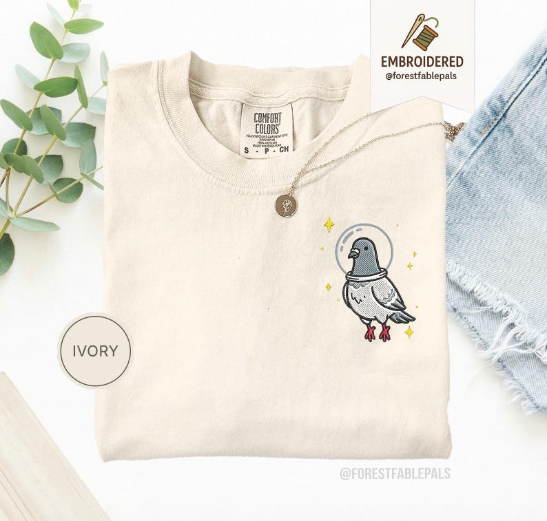 Maglietta con piccione spaziale, maglietta con piccione divertente ricamato, maglietta con simpatico animale cosmico, maglietta Comfort Colors, regalo per amanti dei piccioni, maglietta con animale carino Ivory