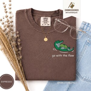 刺繍入り「流れに身を任せよう」ワニ柄シャツ - かわいいワニの赤ちゃんTシャツ、面白い沼地の動物シャツ、コンフォートカラーズの自然愛好家へのギフト