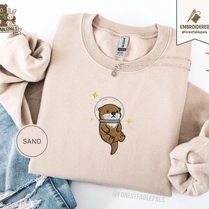 Raum Seeotter Sweatshirt, bestickter Otter Pullover, süßes kosmisches Tier Sweatshirt, Seeotter Liebhaber Geschenk, süßes Tier Sweatshirt Sand