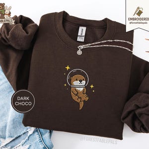 Raum Seeotter Sweatshirt, bestickter Otter Pullover, süßes kosmisches Tier Sweatshirt, Seeotter Liebhaber Geschenk, süßes Tier Sweatshirt Dark Chocolate