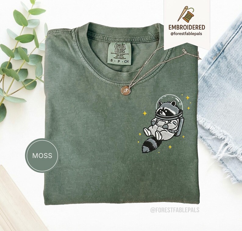 宇宙アライグマTシャツ、刺繍入りおもしろアライグマシャツ、かわいい宇宙動物Tシャツ、コンフォートカラーシャツ、アライグマ好きへのギフト、かわいい動物シャツ Moss