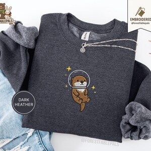 Raum Seeotter Sweatshirt, bestickter Otter Pullover, süßes kosmisches Tier Sweatshirt, Seeotter Liebhaber Geschenk, süßes Tier Sweatshirt Dark Heather