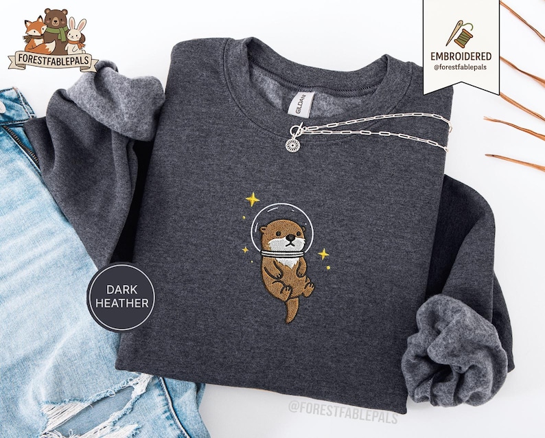 Raum Seeotter Sweatshirt, bestickter Otter Pullover, süßes kosmisches Tier Sweatshirt, Seeotter Liebhaber Geschenk, süßes Tier Sweatshirt Dark Heather