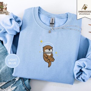 Raum Seeotter Sweatshirt, bestickter Otter Pullover, süßes kosmisches Tier Sweatshirt, Seeotter Liebhaber Geschenk, süßes Tier Sweatshirt Light Blue