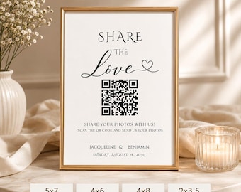 May include: A vertical rectangular sign in a gold frame featuring the black text SHARE THE Love with a heart icon, a QR code, and the text SHARE YOUR PHOTOS WITH US! SCAN THE QR CODE AND SEND US YOUR PHOTOS, JACQUELINE & BENJAMIN, SUNDAY, AUGUST 28, 2030.