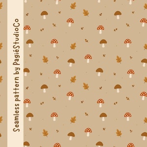 Può includere: Un motivo continuo su sfondo marrone chiaro con illustrazioni ripetute di funghi rossi a pois bianchi, funghi marroni a tinta unita e piccole foglie autunnali arancioni. Il testo "Seamless pattern by PagiéStudioCo" è visibile.
