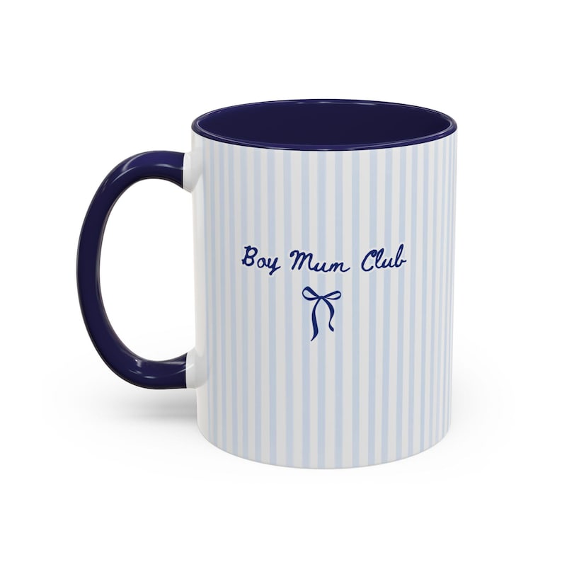 May include: White ceramic mug with blue vertical stripes and a navy blue interior and handle. The mug features the text "Boy Mum Club" in a script font, with a bow illustration below.