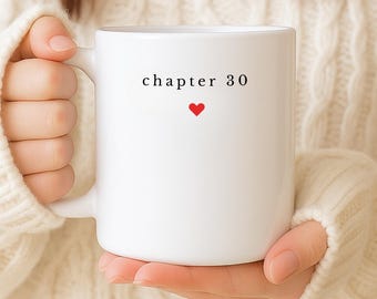 May include: White ceramic mug with the text "chapter 30" in black and a small red heart. The mug is held by a person wearing a white sweater. The bottom of the image has the text "Customise Icon and Age".