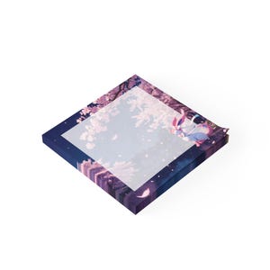 Könnte beinhalten: Quadratischer Notizblock mit einer ruhigen Illustration eines Charakters in einer Kirschblüten-Szene. Der Notizblock hat einen dunkelblauen Rand mit einem lila-rosa Blumendesign. Die Illustration zeigt einen Charakter mit rosa und weißen Akzenten.